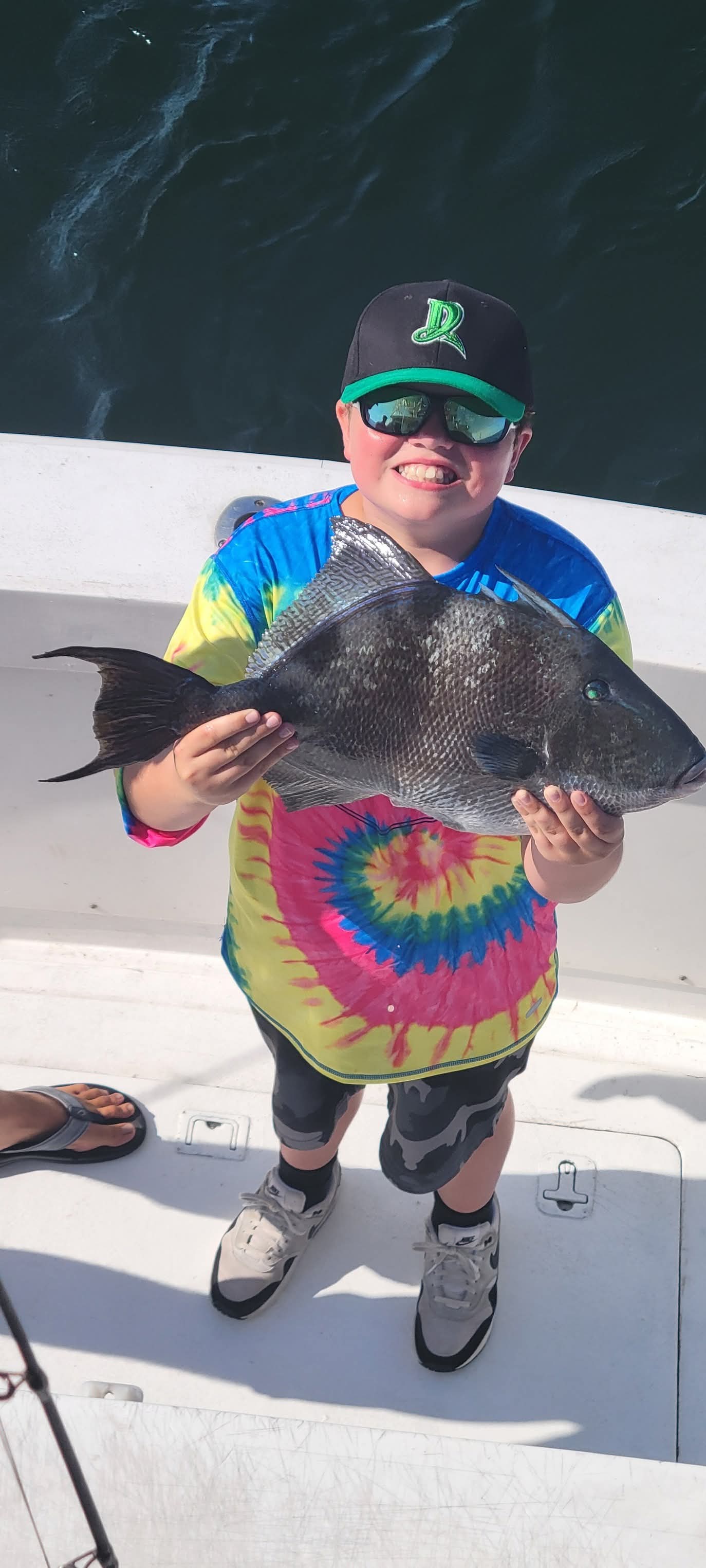 Kid with a big triggerfish on the boat