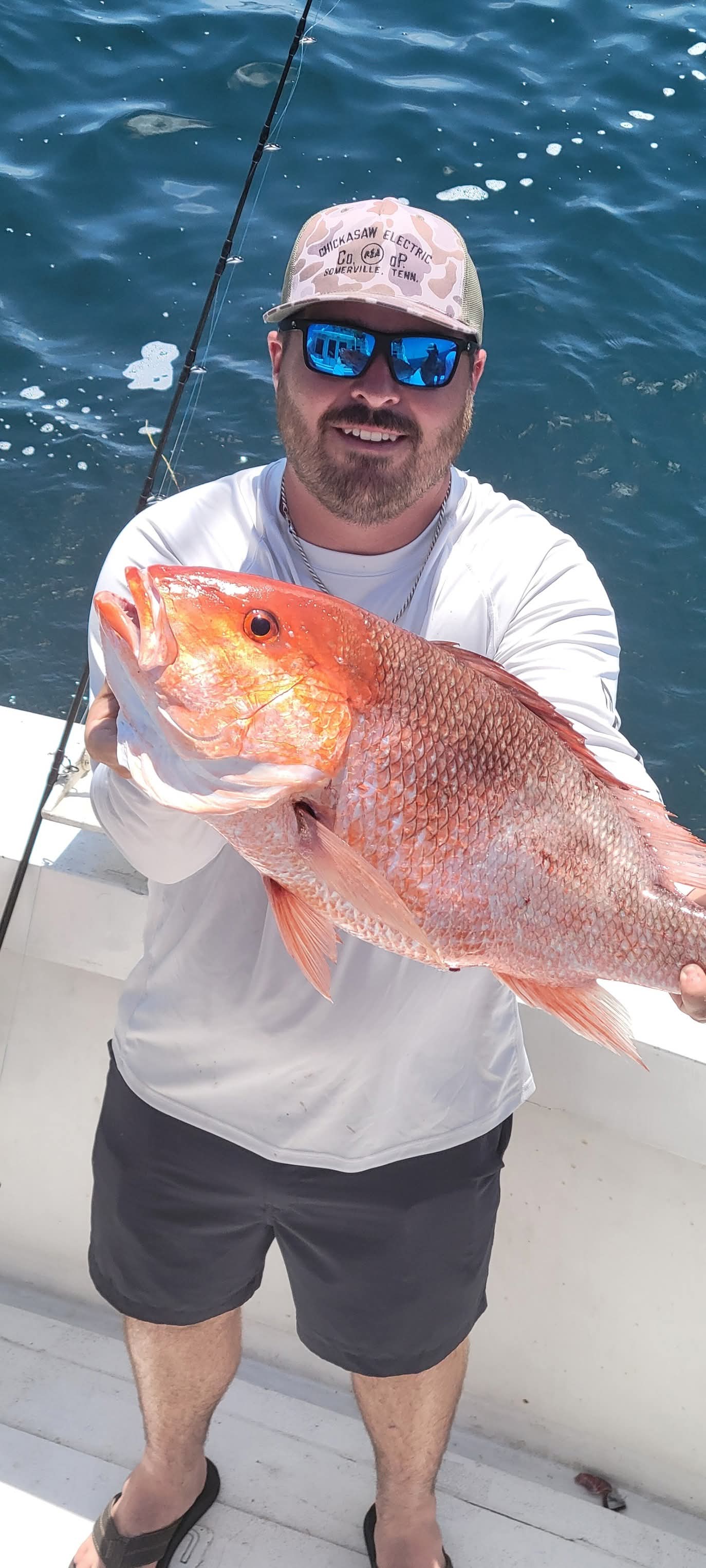 Angler with a solid red snapper on the water